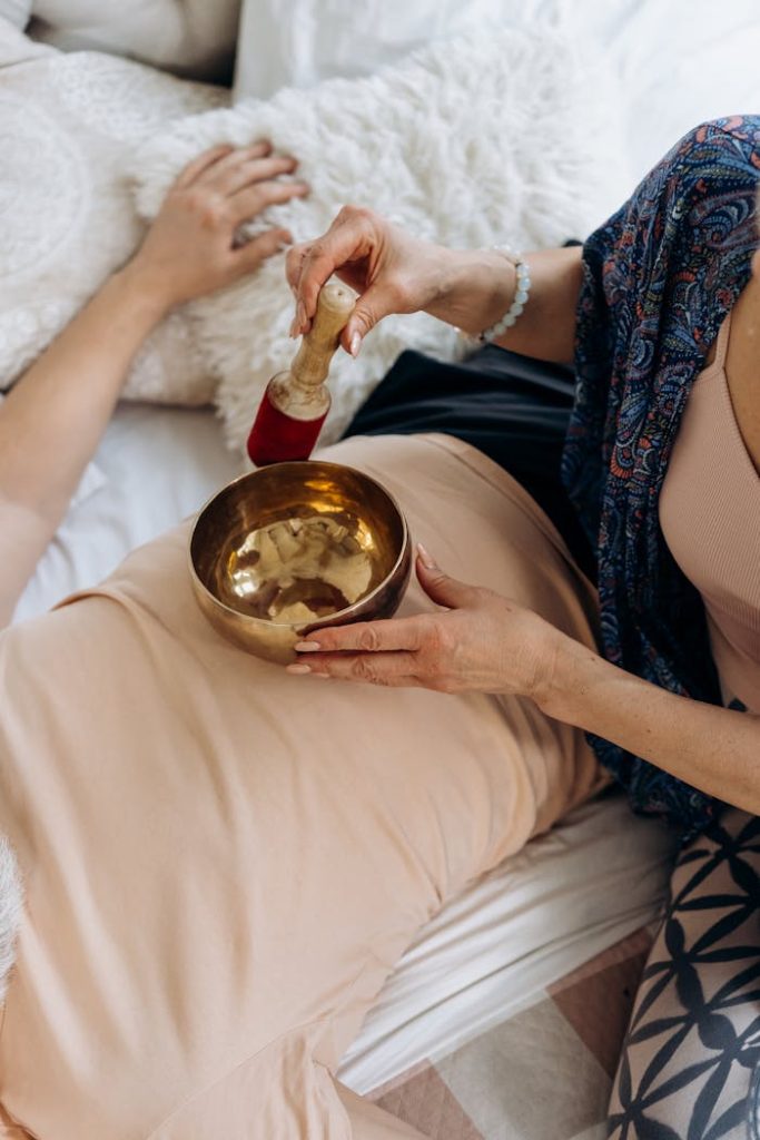 A woman using a singing bowl for relaxation therapy. Perfect for wellness themes.